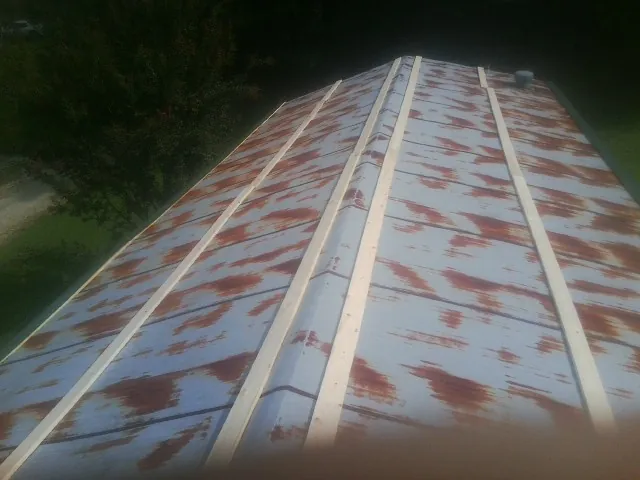 Rusted metal roof panels with new wood purlins before replacement — Storm Damage Roof Repair in George West by Roofing Brothers