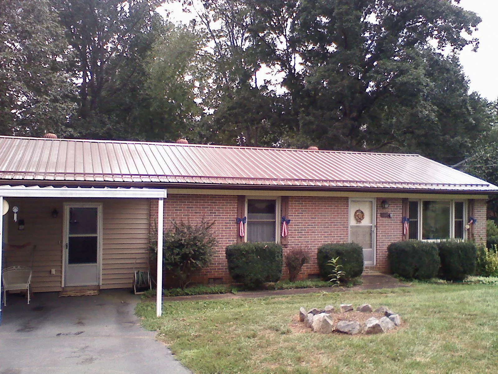 Bronze metal roof and carport on a brick ranch home — Roof Repair work by our crew in George West